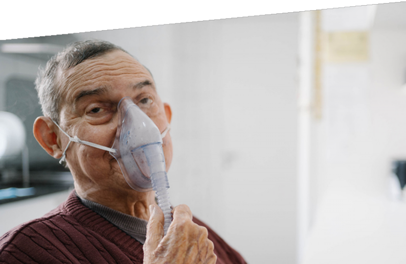 Photograph of a man using an oxygen mask.